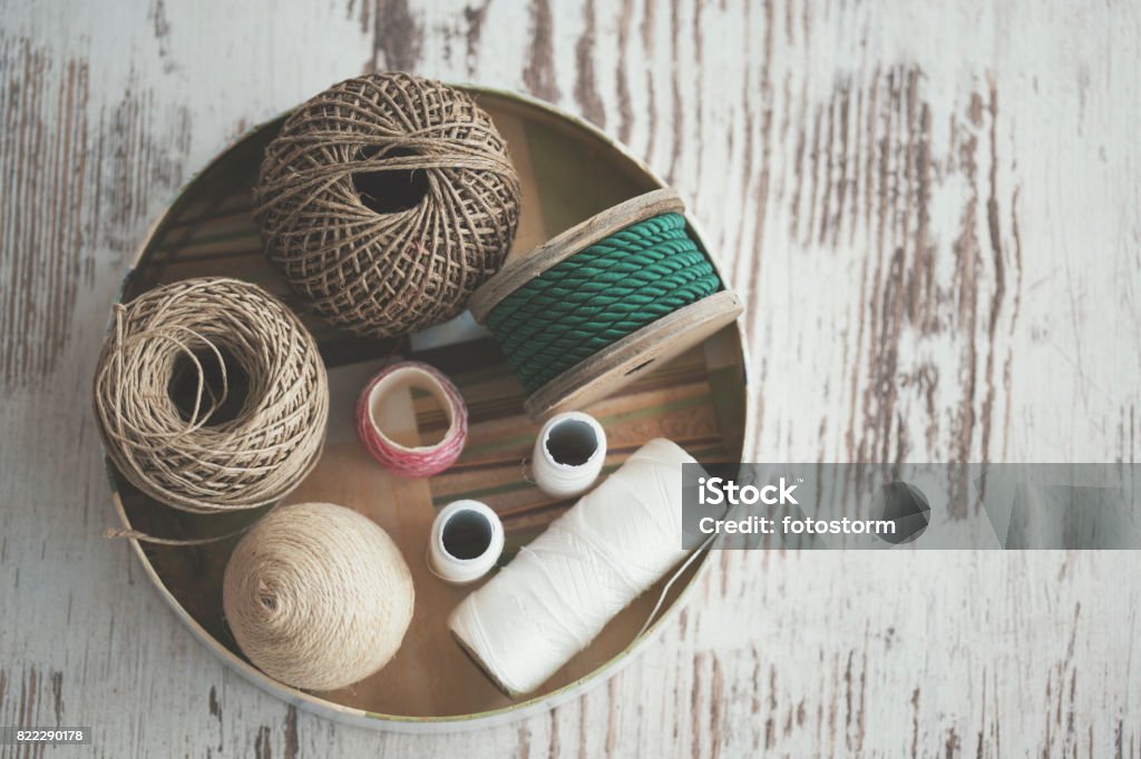 Various decorative ropes - knolling Directly above shot of various decorative ropes in bowl on wooden table, knolling. Thread - Sewing Item Stock Photo
