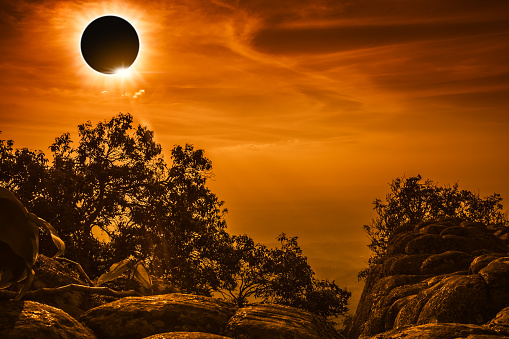 Amazing scientific natural phenomenon. Total solar eclipse glowing on sky and cloudy above view point on the top of mountain, serenity nature  in forest. Abstract fantastic background.