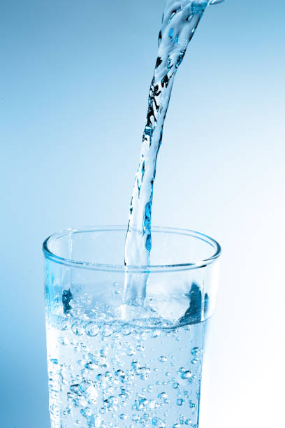 istock Pouring water from bottle into glass with blue light 822293456