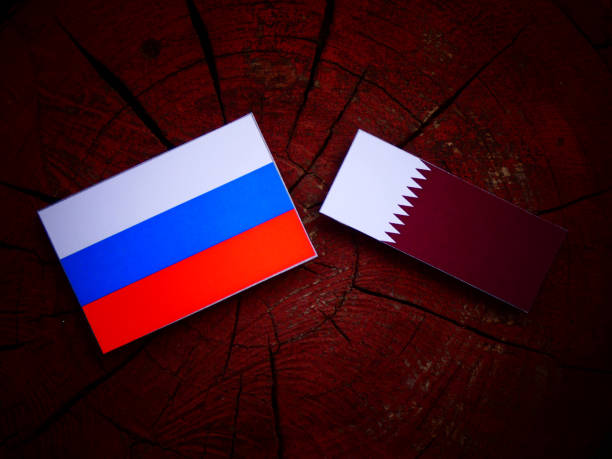 istock Russian flag with Qatari flag on a tree stump isolated 822352264