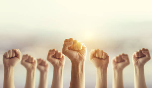 istock Peoples raised fist air fighting and sunlight effect, Competition, teamwork concept. 822352820