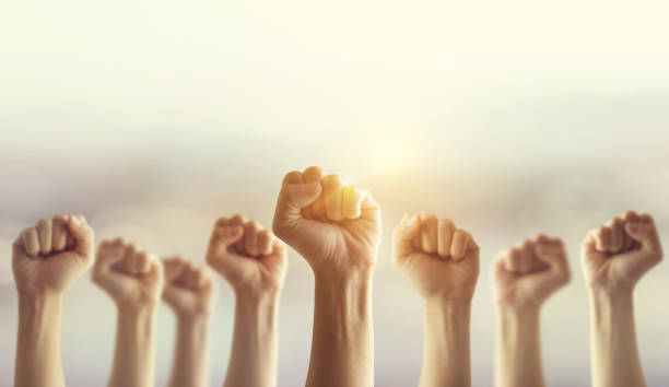 Peoples raised fist air fighting and sunlight effect, Competition, teamwork concept. Peoples raised fist air fighting and sunlight effect, Competition, teamwork concept, background space for text. revolution photos stock pictures, royalty-free photos & images
