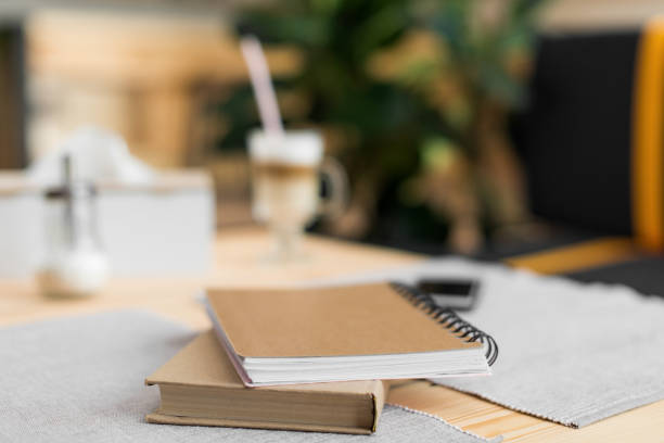 istock close up view of book and notepad on table in cafe, selective focus 822365504