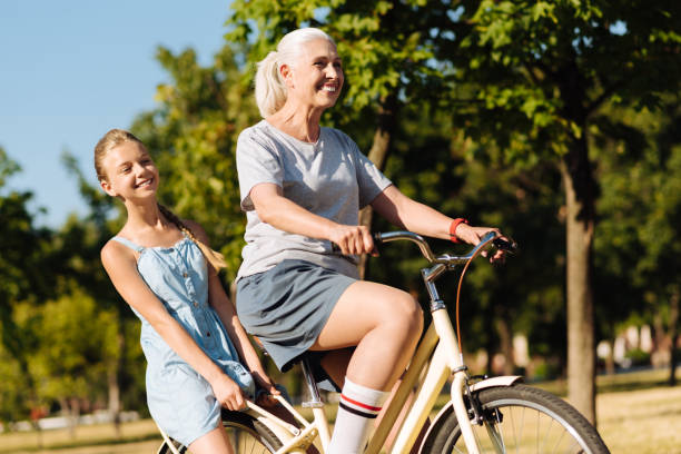 istock Overjoyed aged woman riding bicycle in the park 822369520