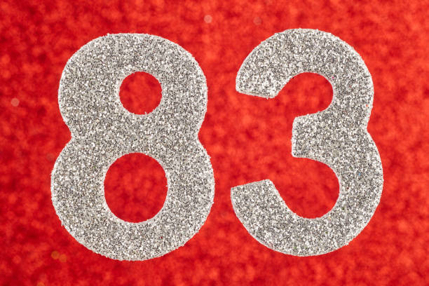 istock Number eighty-three silver color over a red background. Anniversary. 822380122