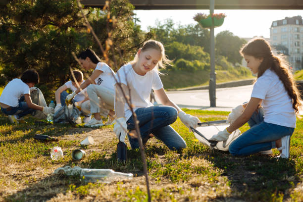istock Little children cleaning grass from rubbish 822389908
