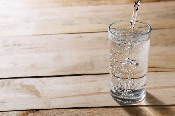 istock Pour drinking water into a glass of water. 822403220
