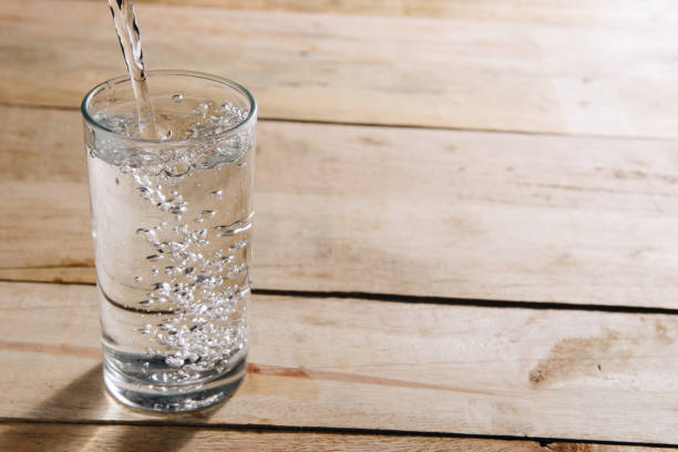 istock Pour drinking water into a glass of water. 822403222
