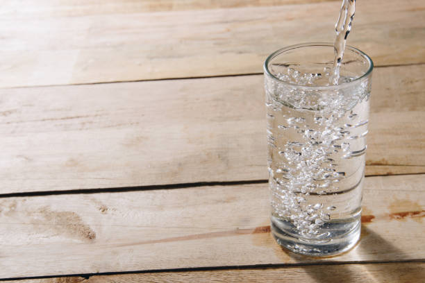 istock Pour drinking water into a glass of water. 822403246