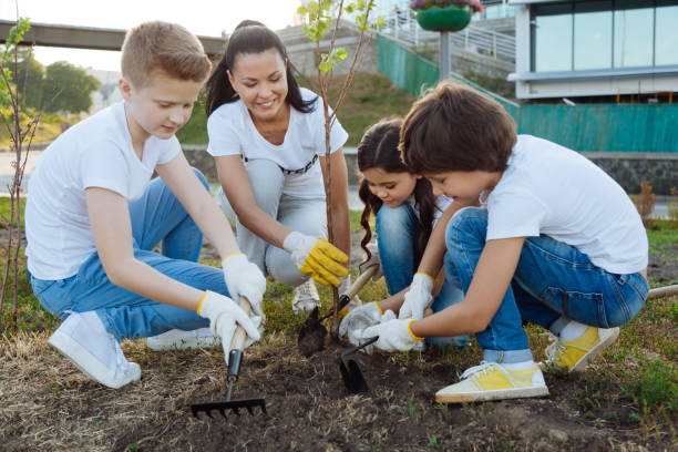 istock Smiling leader of volunteer group holding sapling in right hand 822403252