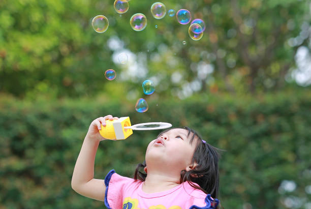 istock Cute little girl playing bubble in the park. 822420530