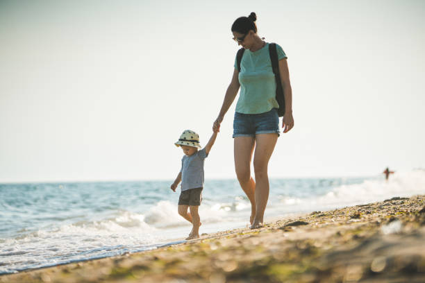 istock Mother and son walking on the beach 822420688