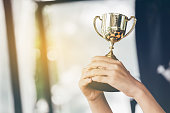 Teenage girls' hands are holding trophies, congratulations on success.Conception of victory in the competition.