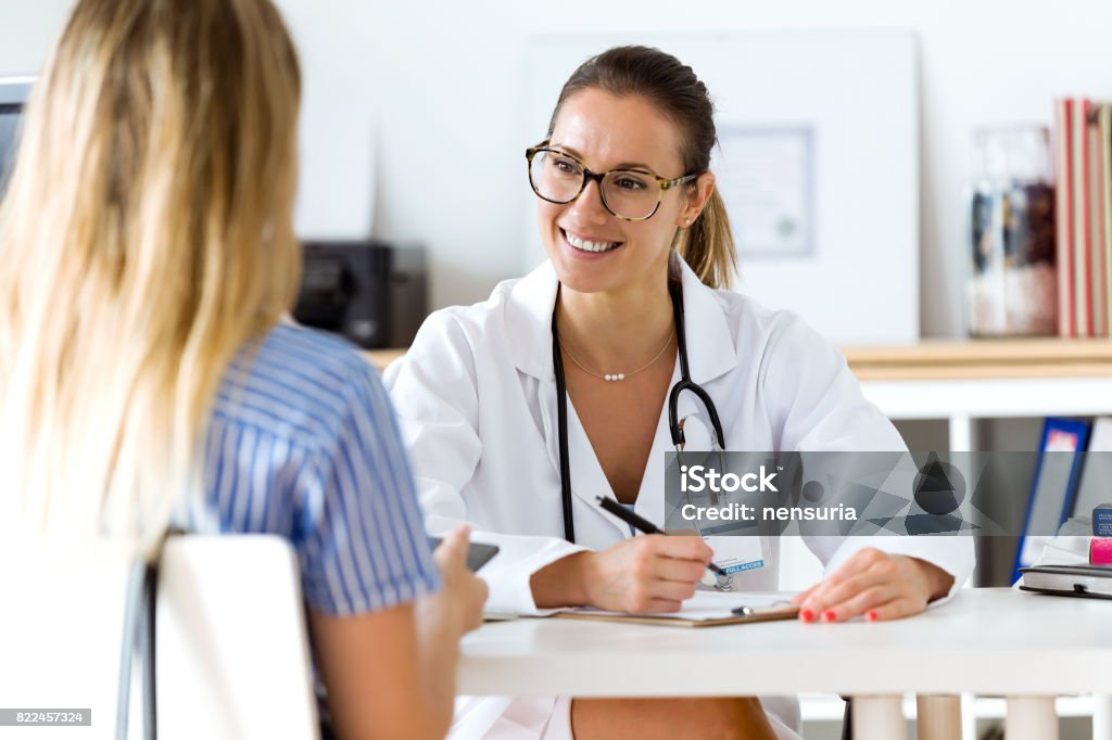 Female doctor explaining diagnosis to her patient. Portrait of female doctor explaining diagnosis to her patient. Doctor Stock Photo
