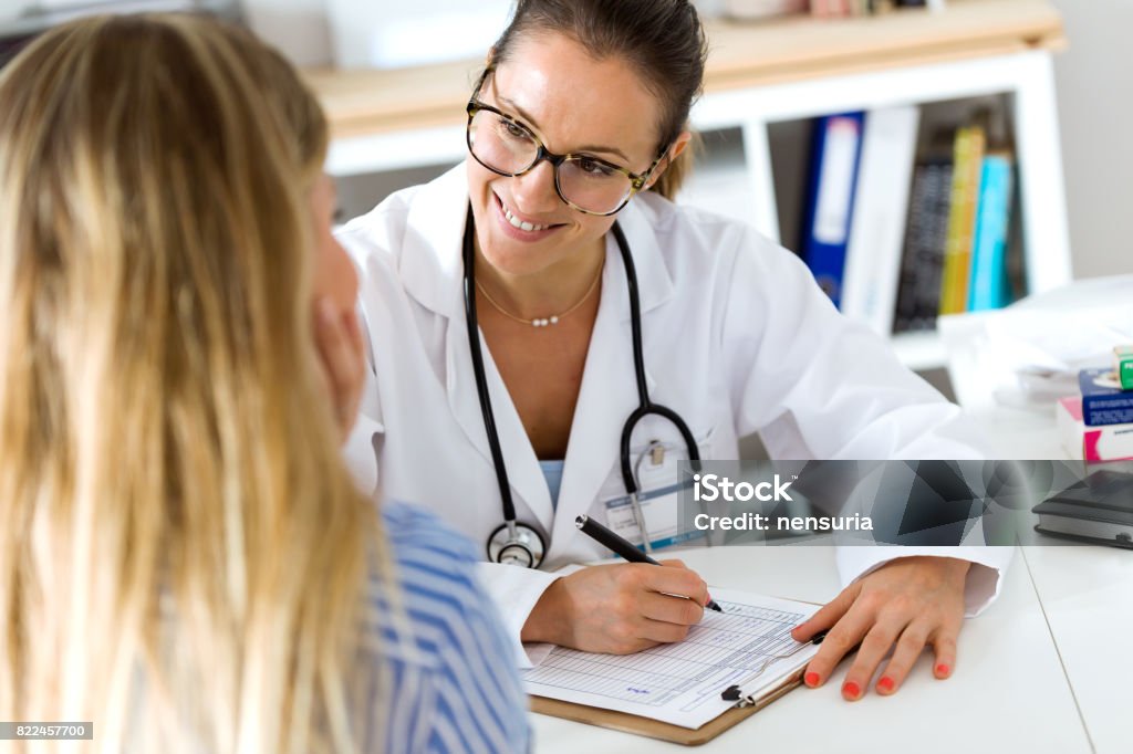 Female doctor explaining diagnosis to her patient. Portrait of female doctor explaining diagnosis to her patient. Patient Stock Photo