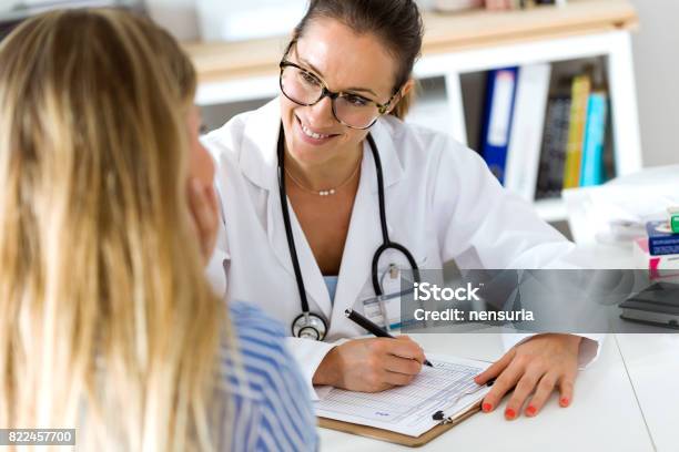 Female Doctor Explaining Diagnosis To Her Patient Stock Photo - Download Image Now - Patient, Doctor, Medical Research