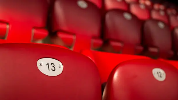 Unlucky Number Thirteen On Empty Red Chairs