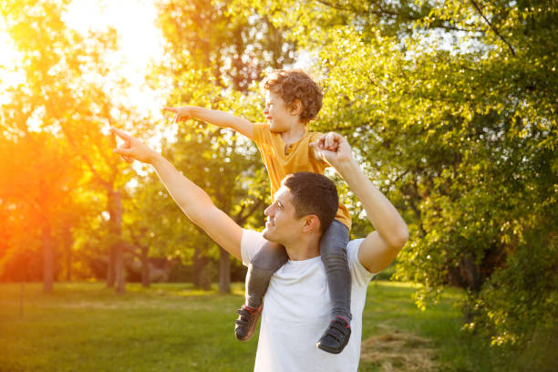 istock Father with son pointing away in park 822478760