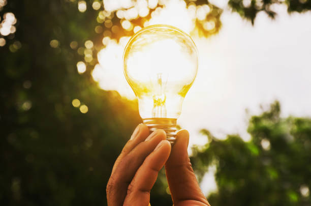 istock hand holding light bulb with sunset power energy concept 822478902
