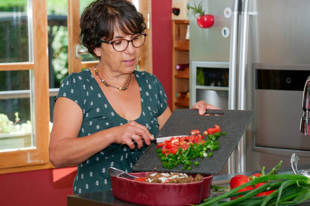 istock smiling middle-aged brunette woman preparing meal 822500696