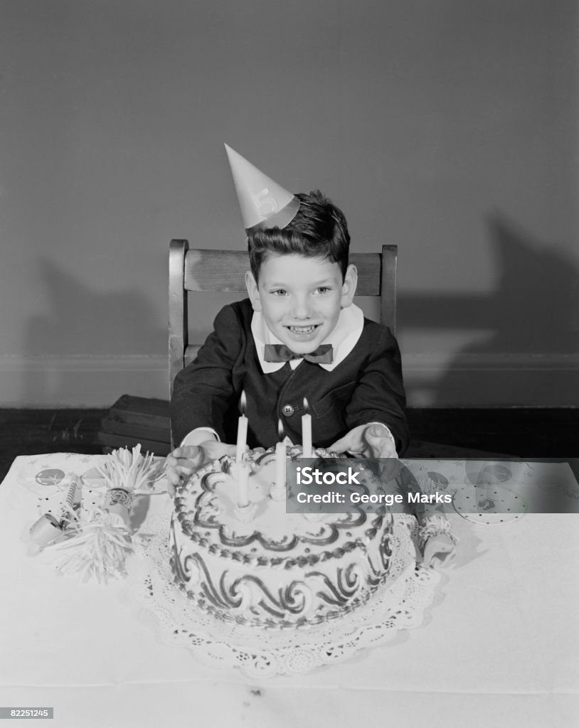 Garçon (6-7) assis à table avec Gâteau d'anniversaire, portrait - Photo de Image en noir et blanc libre de droits