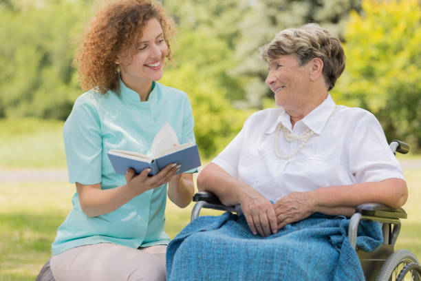 istock Nurse reading elderly woman in a garden 822518208