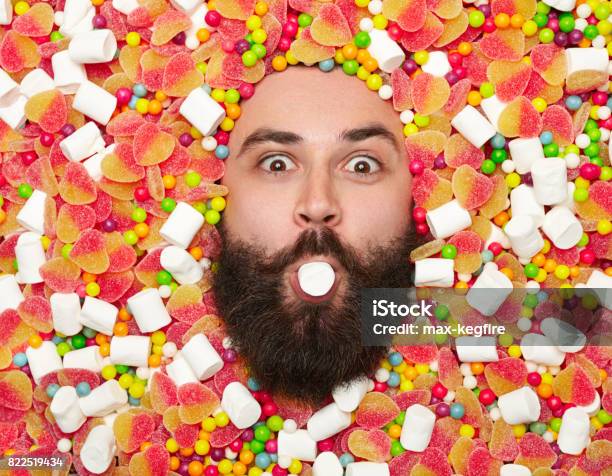 Bearded Man Holding Marshmallow In Mouth Stock Photo - Download Image Now - Abundance, Adult, Adults Only