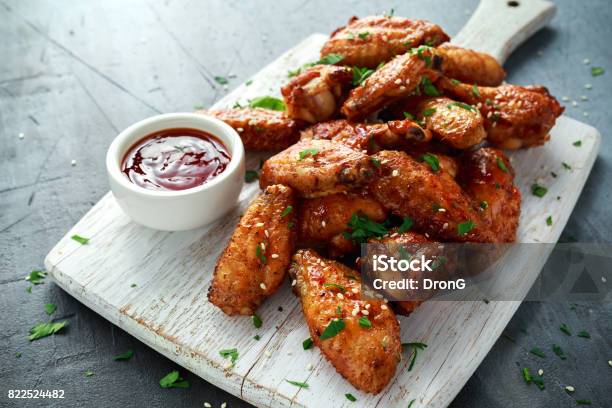 Gebackene Hühnerflügel Mit Sesam Und Süßer Chilisauce Auf Weißen Holzbrett Stockfoto und mehr Bilder von Hühnerflügel