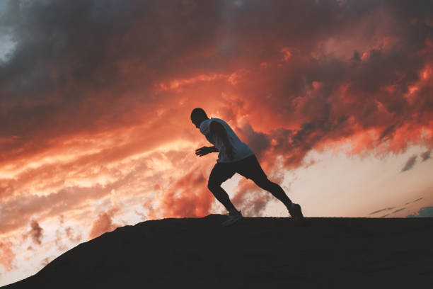 istock Athlete runs around the hills. Strong athlete runs through the mountains at sunset 822525122