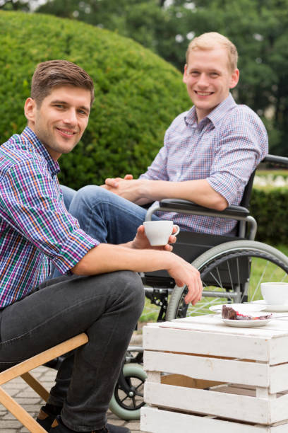 istock Man drinking coffee with his disabled friend 822526712