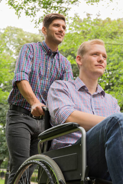 istock Man pushing brother on wheelchair 822526714