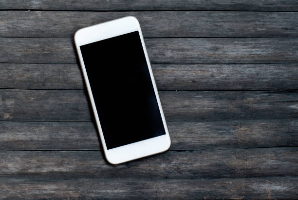 istock White smartphone on grey wooden background. Personal device mockup 822526858