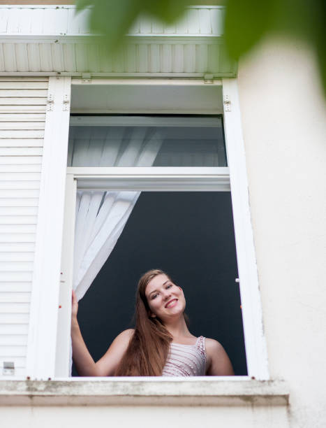 istock Young woman looking out of window 822539486