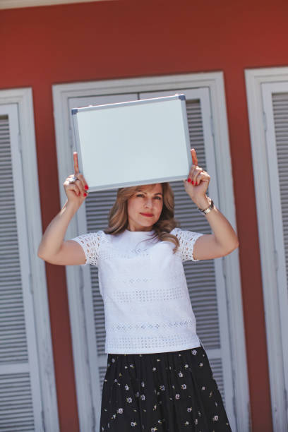 istock Women teacher lady showing empty whiteboard, smiling, wore classic style 822549100