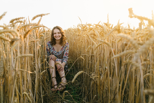 Young Caucasian woman sitting in the wheat field