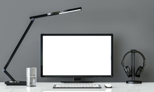Minimal style  black and white working desk with gray wall 3d rendering image.There are white glossy desk ,modern lamp,headphone and water glass