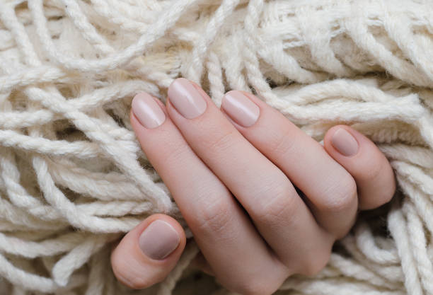 istock Beautiful female hand with beige nail design 822572456