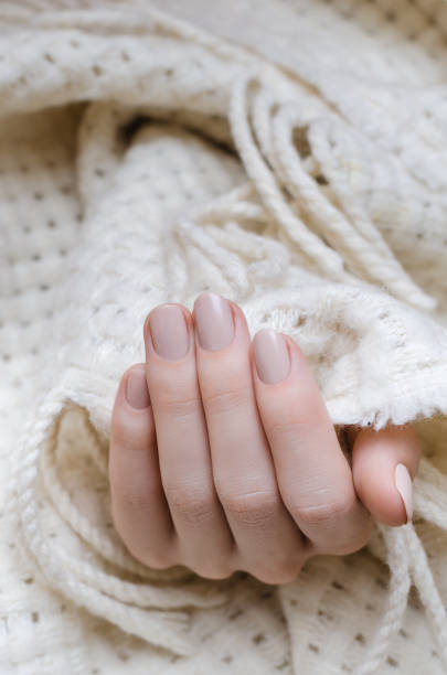 istock Beautiful female hand with beige nail design 822573640