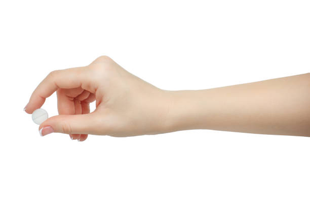 istock Hand holding a pill between thumb and forefinger isolated on white background. manicured hand 822578708