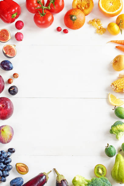 istock Rainbow colored fruits and vegetables food frame on a white table with copy space. 822586046