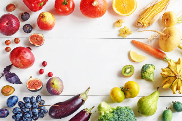 istock Rainbow colored fruits and vegetables on a white table with copy space. 822587150