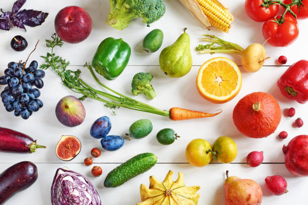 vista dall'alto di frutta e verdura color arcobaleno su un tavolo bianco. - healthy eating multi colored orange above foto e immagini stock
