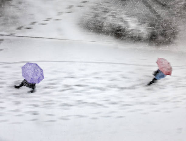 People Walking With Umbrellas In Snowstorm People walking with umbrellas in snowstorm. Blurred motion - view from above. slippery unrecognizable person safety outdoors stock pictures, royalty-free photos & images