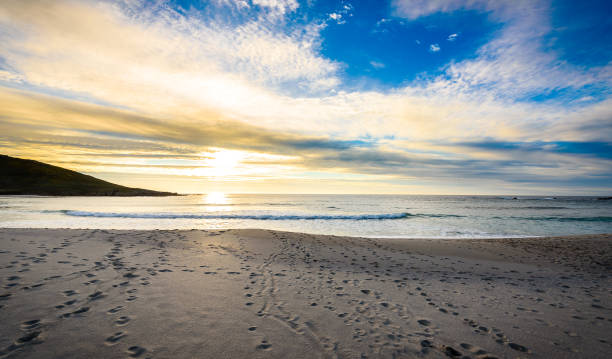 istock Footsteps tracks in sand on beach with sunrise or sunset. 822606666