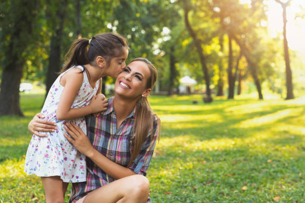 istock Mother and daughter outdoors playing, kissing and hugging 822609742