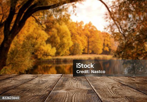 istock Empty wooden table over the autumn landscape 822623640