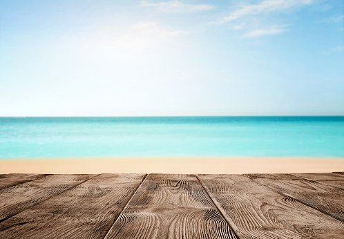 Summer background, close up of old empty wooden pier over the turquoise ocean with copy space