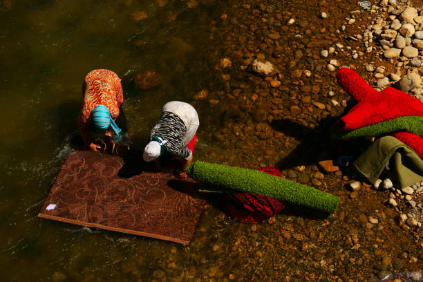 Young people on a stilt platform on a canal, under a concrete bridge in North Jakarta, Indonesia.