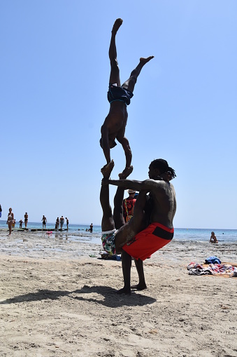 Ibiza , Spain - July 11, 2017:Acrobatic Three young men in a street Acrobatic  show On a popular beach Ibiza, Spain.