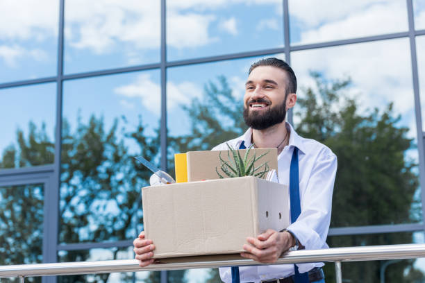 happy businessman with cardboard box with office supplies in hands standing outside office building, quitting job concept happy businessman with cardboard box with office supplies in hands standing outside office building, quitting job concept quitting a job stock pictures, royalty-free photos & images